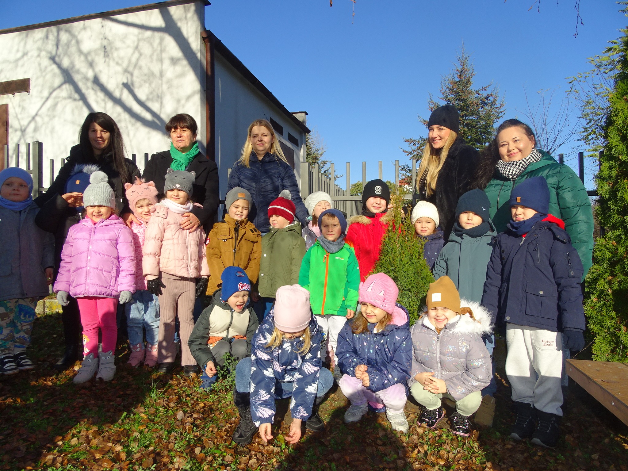 dzieci sadzą zielone drzewa