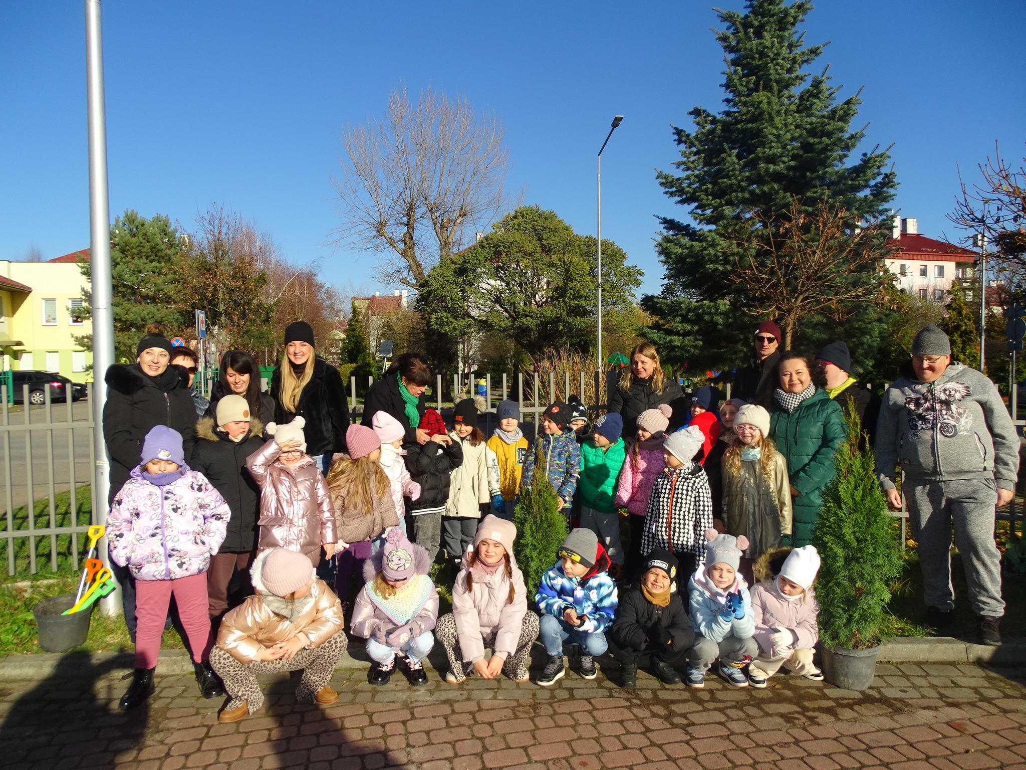 dzieci sadzą zielone drzewa